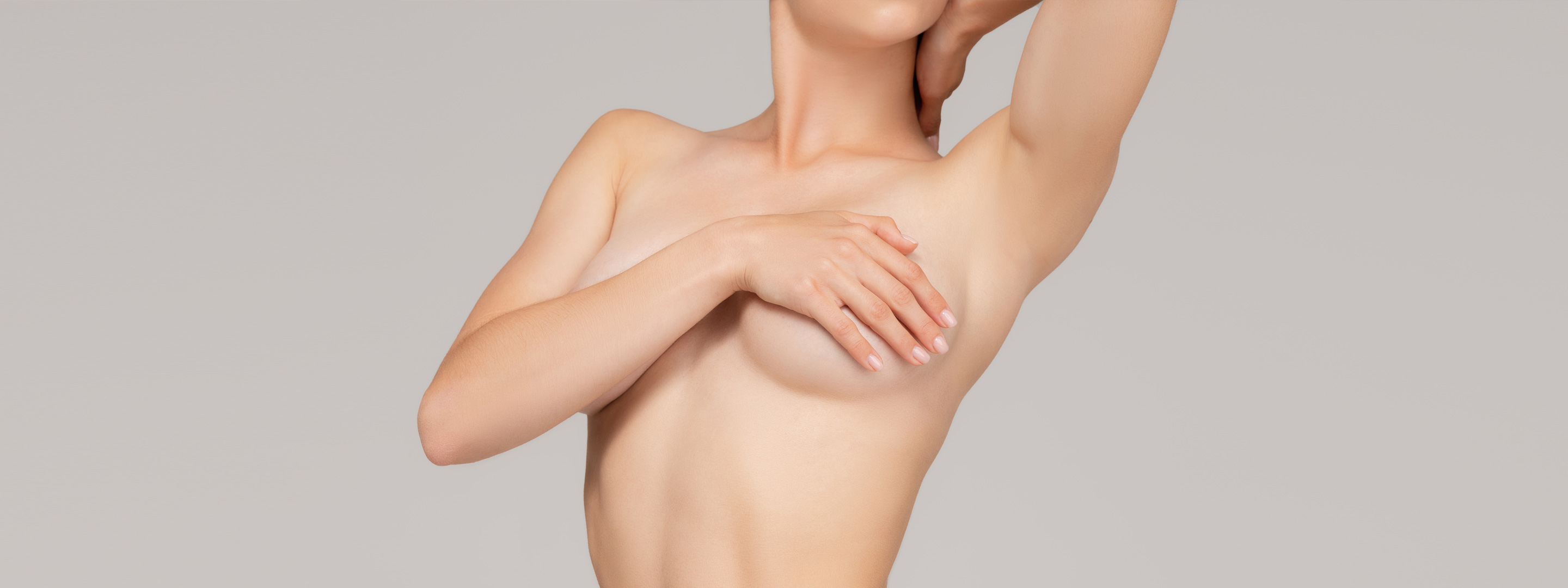 Auf dem Titelbild zu sehen ist ein Ausschnitt eines Fotos von einer schlanken, plastisch-ästhetischen und gesunden Frau, die ihre Brüste verdeckt, nach der Brustvergrößerung beziehungsweise Mammaaugmentation.